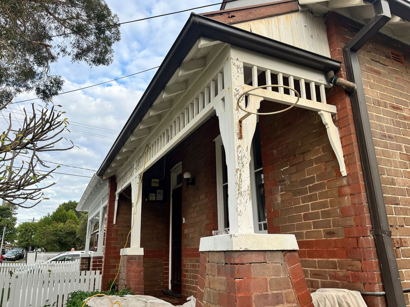 Federation porch with weathered paint on the timber posts and brackets