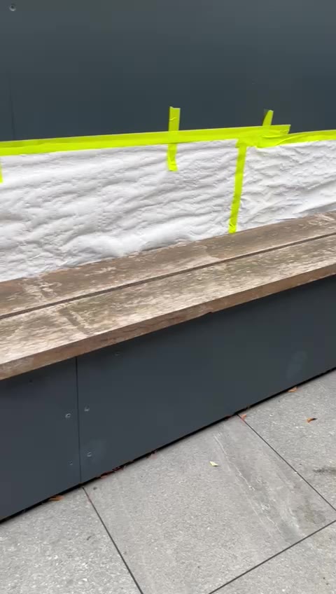 Weathered hardwood bench masked and prepared for oiling